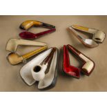 A collection of cased meerschaum pipes, including four with amber mouthpieces (5)