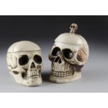 Two novelty tobacco jars with covers, in the form of skulls, largest 22 cm high (2)