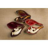 Three equestrian carved meerschaum cheroot holders, each with amber mouth piece and cased, largest