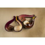Two cased meerschaum curved pipes, one with silver collar, both having amber stems (2)