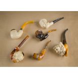 Three meerschaum pipe bowls with white metal mounts, two with carved lobed design, with wooden and