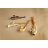 Three meerschaum carved cheroot holders, two carved with pugs, another of a spaniel, each having
