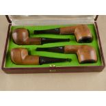 A cased set of four Longchamp estate pipes, the leather cased bowls, with vulcanite logo marked