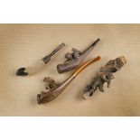 Three carved Black Forest cheroot holders, two with bears on naturalistic bases, and another of '