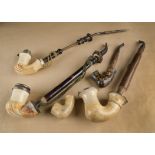 A collection of six meerschaum pipes, five with carved faces, including one young woman, three of