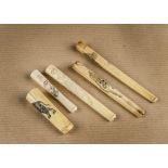 A small collection of Art Deco Japanese ivory cigarette holders, decorated with tigers, flowers