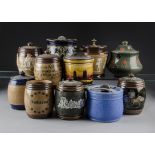 A collection of eleven tobacco jars, by Royal Doulton, including three two tone brown examples one