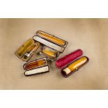 Three amber and 9ct gold cigar holders, all of tapered design in fitted cases, together with a