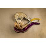 A large cased meerschaum pipe, the bowl carved with an eagles claw interspersed with wolf, dog and