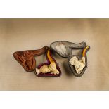 Two cased meerschaum cheroot holders, both bodies carved with young females each having amber stems,