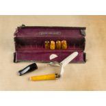 An amber and gold cheroot holder, in suede case together with a collection of five amber mouth