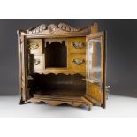 An Edwardian stained oak smokers cabinet, having a pair of glazed panel doors, with brass pipe