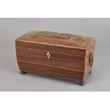 A mahogany and satin strung sarcophagus shaped tea caddy, with lion mask handles, turned bun feet,