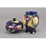 A William Moorcroft pottery baluster vase, 14.5 cm H in the Leaf & Berries pattern c. 1920-1949, and