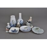 A collection of Royal Copenhagen porcelain, including vases, pin dishes, bird groups, a seated