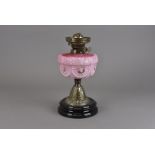 A Victorian Veritas oil lamp base, having opaque pink glass reservoir with relief foliate decoration
