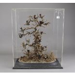 A large cased taxidermy study, humming birds in flight and nesting within naturalistic setting,
