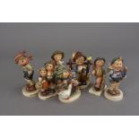 Seven Hummel figures, including March Winds, Home from Market, Surprise, Merry Wanderer, The Long