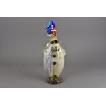 A Murano glass clown, modelled looking sideways in blue hat with blue hair on circular base,