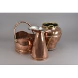 A collection of brass and copper, including a large pair of jugs, two helmet shaped coal scuttles, a