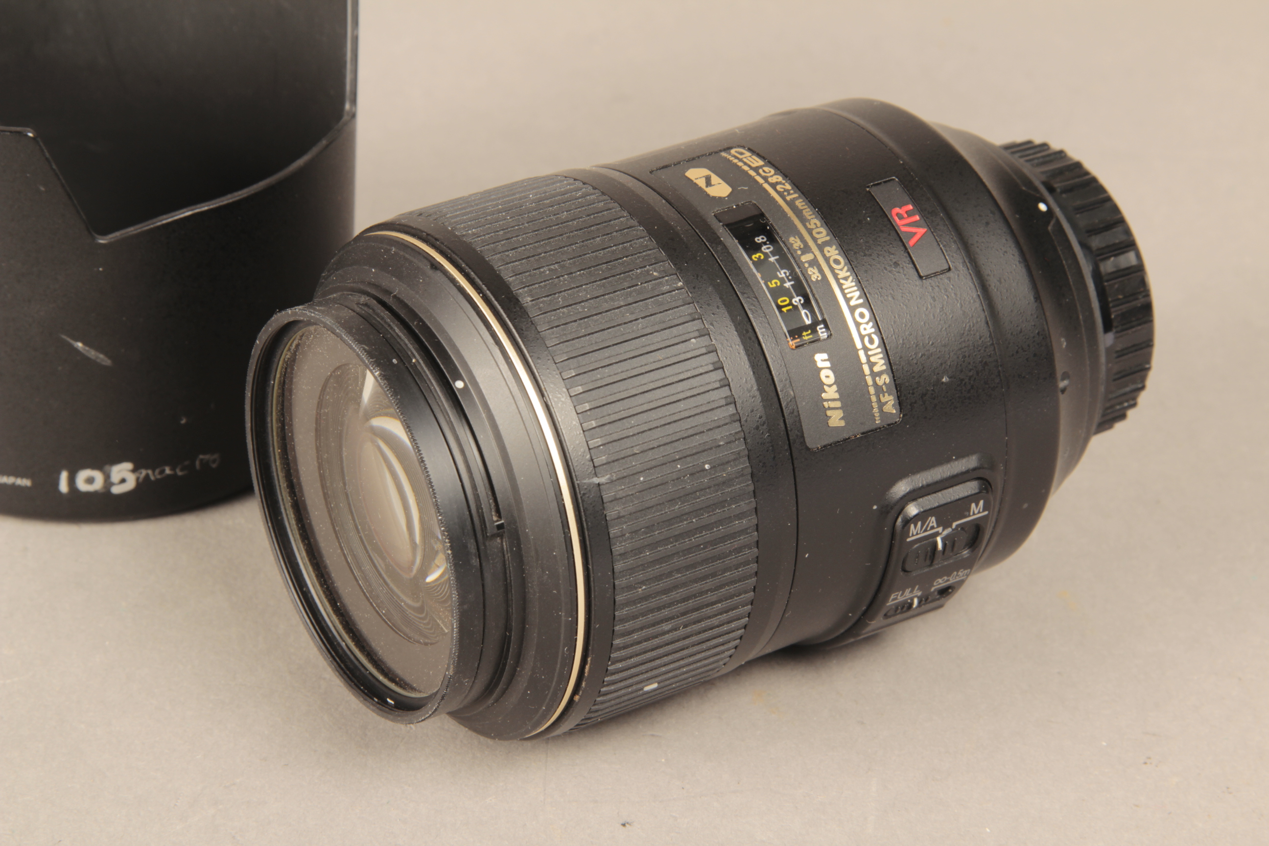 A Nikon AF-S 105 Micro Lens, F2.8G ED VR type with caps and hood