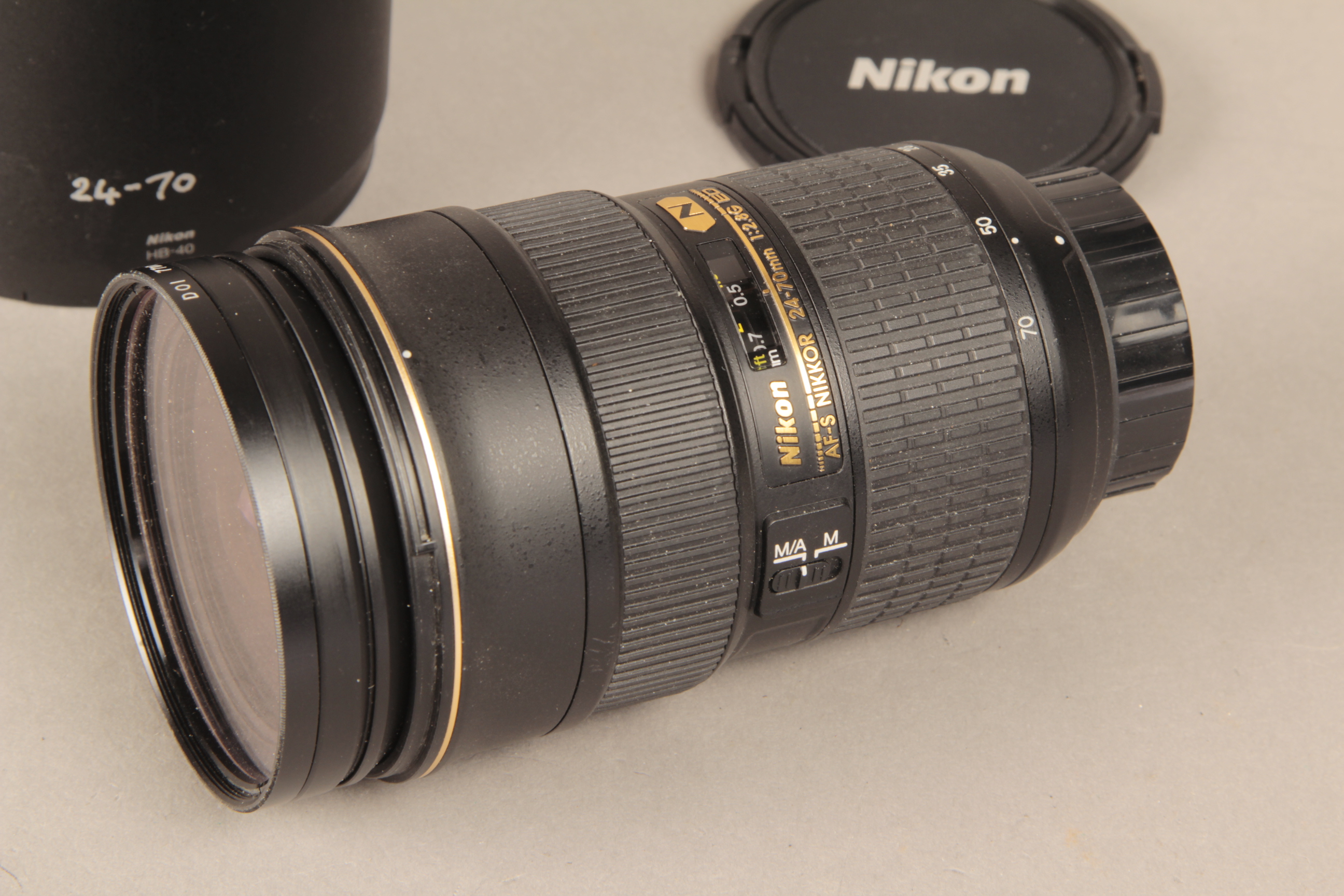 A Nikon AF-S 24-70 Lens, F2.8G ED type with caps and hood