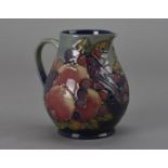 A Moorcroft Pottery jug, in the Finch pattern with pomegranates and berries 14.5 cm H