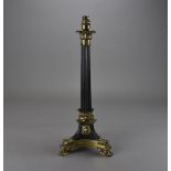 An Empire ormolu candle stick, with fluted column with leaf capital, over an Egyptian influence