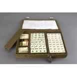 A mid to late 20th century Mah Jongg set, in bone and bamboo presented in silk covered box 33.5 cm x
