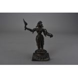 A 17th or 18th century parcel gilt Indian bronze figure, possibly Lakshmi, holding aloft a torch,