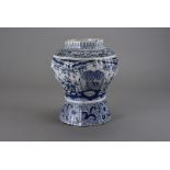 A 19th century delft baluster vase, of ribbed form and decorated with a stylised floral landscape