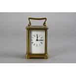 A mid 20th century brass carriage clock, having black Roman numerals to white enamel face, including