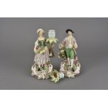 A pair if porcelain figural candlesticks, modelled as a flower gatherer and suitor in 18th century
