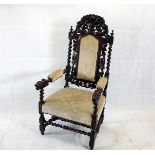 A Victorian oak Carolean style arm chair, with carved mythical beasts and baskets of fruit, with