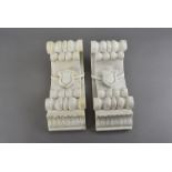 A pair of white alabaster corbels, having scroll design with shield relief to centre, 33cm H (2)
