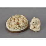 A signed Japanese ivory ojime bead, modelled as a seated bear together with a Chinese ivory