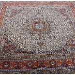 A 20th Century Persian square carpet, the central panel decorated with radiating roundels with
