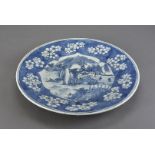 A 19th century Chinese porcelain charger, decorated with figural lakeside landscape within a