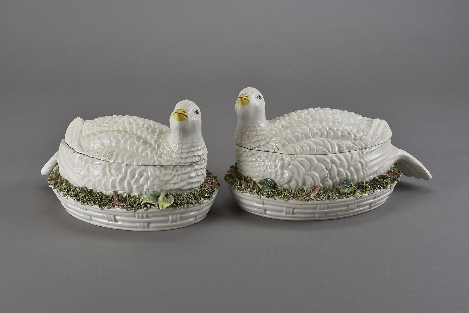 A pair of Palissy style majolica vegetable tureens, modelled as recumbent Arctic partridge on a