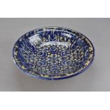 An Hispano-Moresque tin glazed bowl, decorated with geometric floral pattern in blue and yellow,