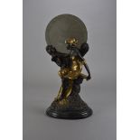 An Art Nouveau style bronze figural table mirror, as a seated maiden beneath the moon, on black