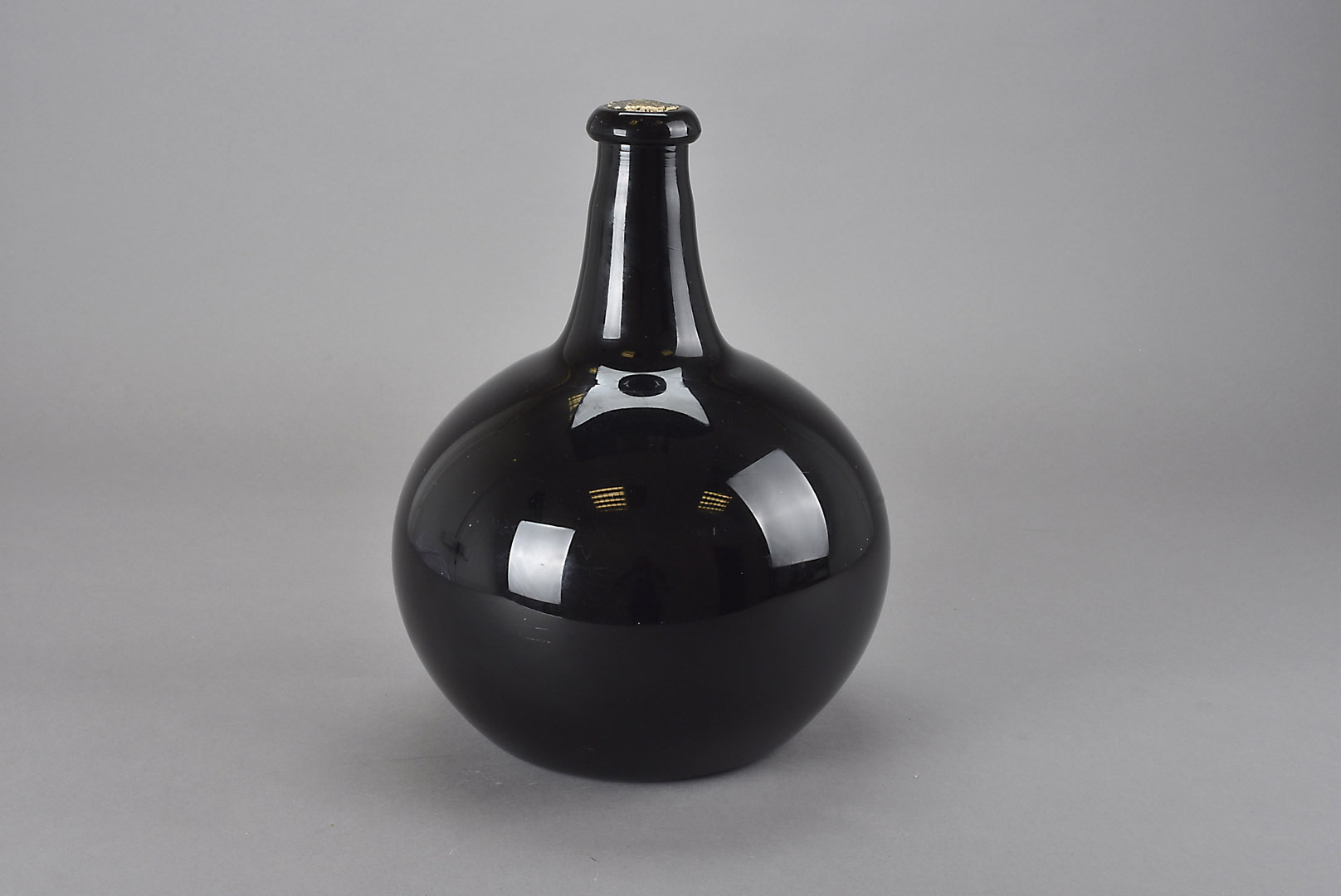 An 18th century amethyst glass sealed magnum onion wine bottle, the dark purple glass of generous
