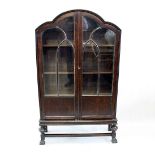An Art Deco display cabinet, the dark oak cloud style cabinet, with a pair of panel doors,