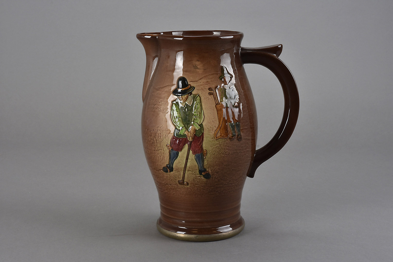 A Royal Doulton Golfing jug, moulded in low relief with figures playing golf, with silver foot rim