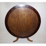 A 19th century mahogany snap top circular extending dining table, on tripod support, having six