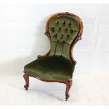 A Victorian spoon back walnut chair, with green button back upholstery and ceramic casters