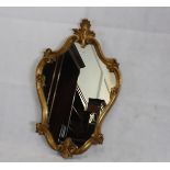 A 20th Century shield shaped gilt framed mirror, 83 cm high x 50 cm wide