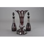 A 19th century bohemian style cut glass ruby flash vase, together with a pair of oil and vinegar