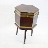 A Regency mahogany and brass band hexagonal wine cooler, on three tapering legs, with brass casters,