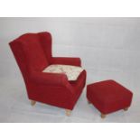 A modern red upholstered wing back armchair, together with matching ottoman